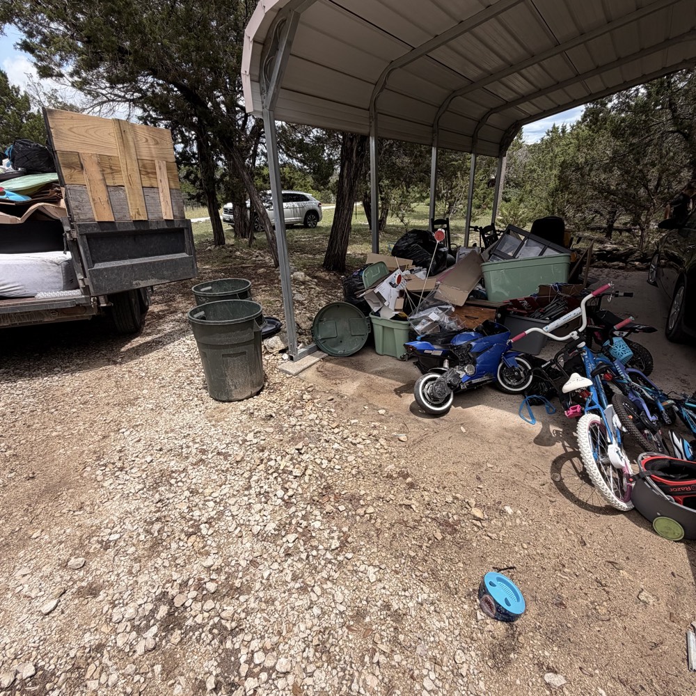 Carport packed with junk, bikes and bins before Loredo Hauling cleared it