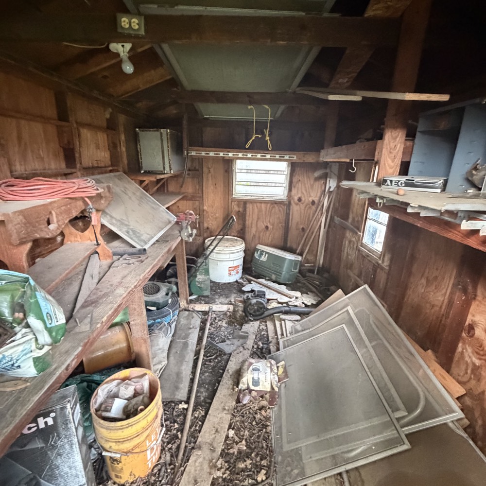 Backyard shed crammed with old tools and debris before clean-out